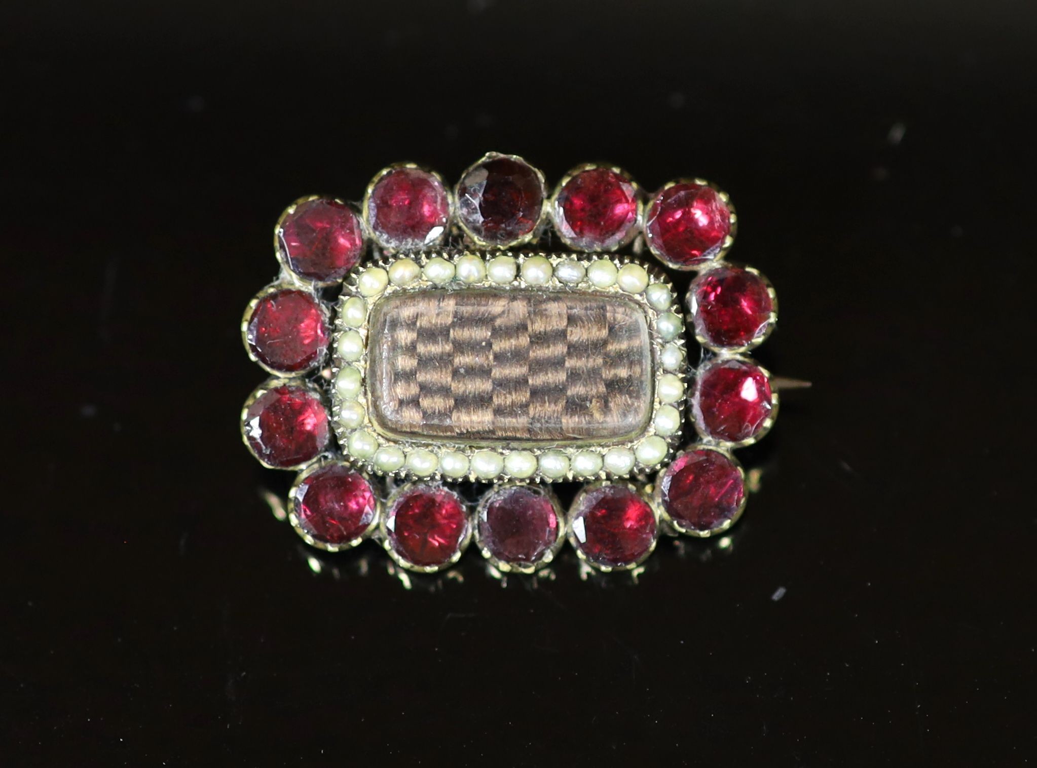 A 19th century gold plated, garnet and seed pearl set mourning brooch